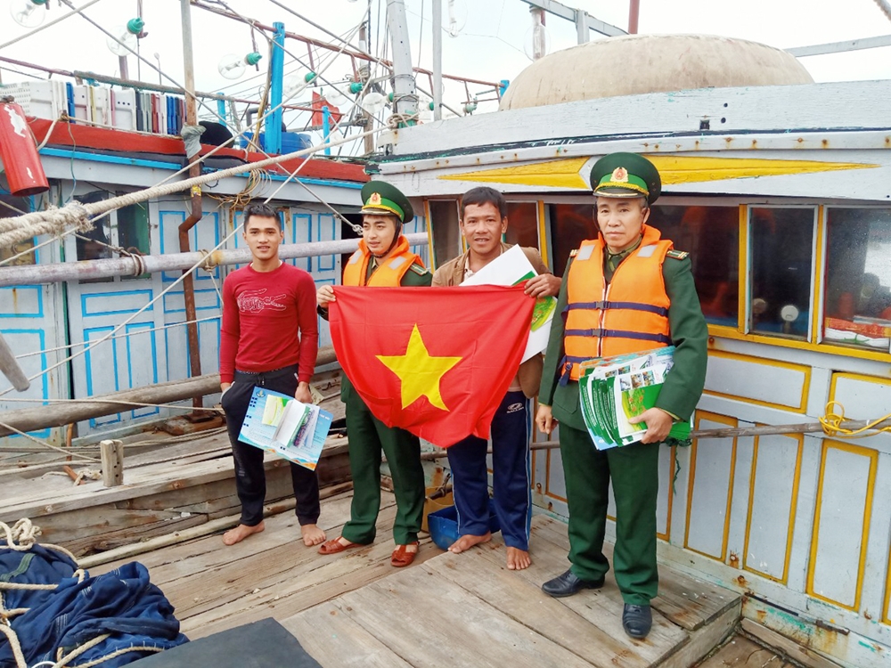 Đồn BP Bạch Long Vĩ, BĐBP Hải Phòng tặng cờ Tổ quốc cho các chủ phương tiện đánh bắt hải sản khu vực ngư trường Bạch Long Vĩ. Ảnh: Mạnh Cường
